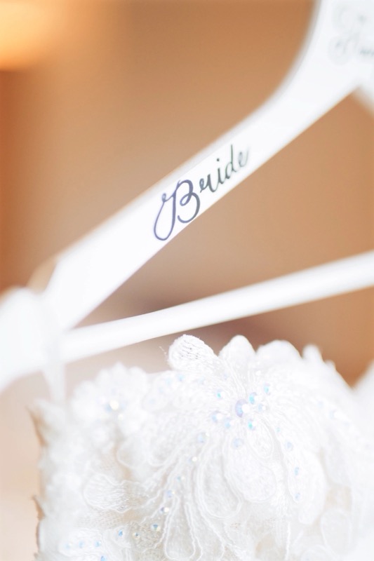 Detail: Brautkleid auf einem Kleiderbügel mit der Aufschrift Bride